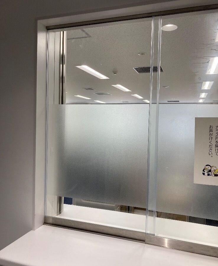 受付窓の透明ガラス 四方糸面フチ磨き加工 室内側引き手掘り加工1箇所 外側全面透明飛散防止フィルム貼り 室内側フロストフィルム部分貼り交換｜福岡市中央区の施工写真