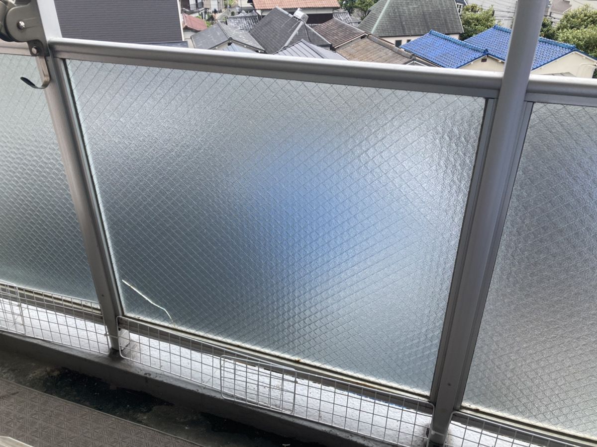 ベランダの手すりにはめ込まれた網入りガラス